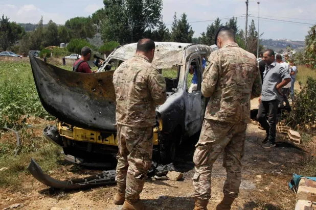 Lebanese army soldiers inspect the wreckage of a car after an Israeli airstrike targeted the village of Bourj el-Moulouk, approximately 18 kilometers from the city of Nabatieh, last week (AFP)