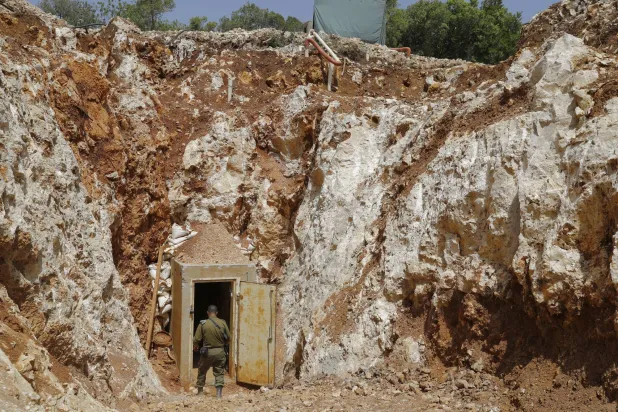 Lübnan sınırında 2019 yılında keşfedilen bir tünelin girişindeki bir İsrail askeri (AFP)