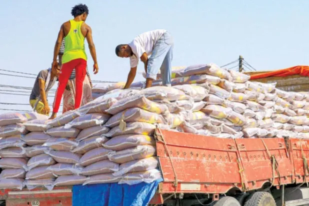 Workers load up onto the back of a truck sacks of food supplies at the Red Sea port of Hodeidah in western Yemen, April 5, 2022. (AFP)