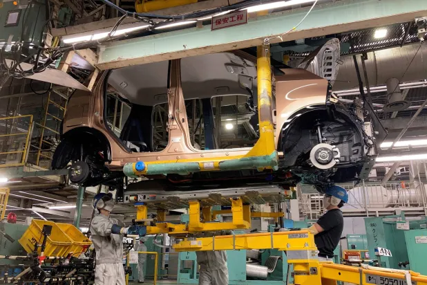 عمال يقومون بتثبيت بطارية في إحدى السيارات الكهربائية بمصنع ميتسوبيشي باليابان (رويترز)
