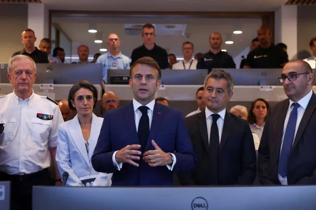 وزير الداخلية جيرالد دارمانين (وسط) إلى جانب الرئيس إيمانويل ماكرون ومدير شرطة باريس يوم 27 يوليو بمناسبة لقاء مع القوى الأمنية المكلفة حماية الأولمبياد (رويترز)