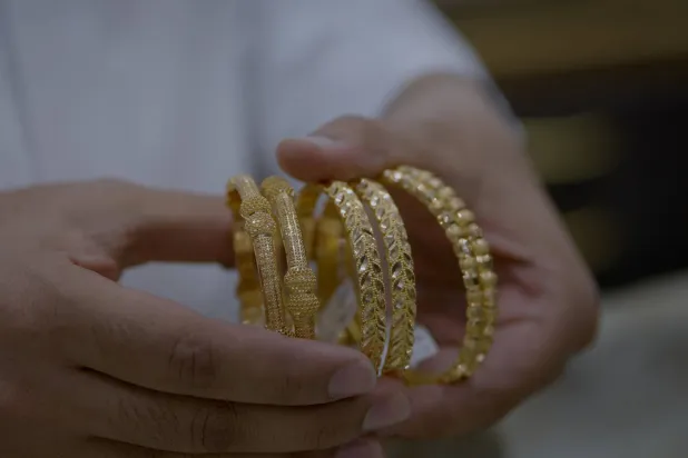 بائع يحمل أساور الذهب في أحد متاجر المجوهرات بالعاصمة السعودية الرياض (تصوير: تركي العقيلي)