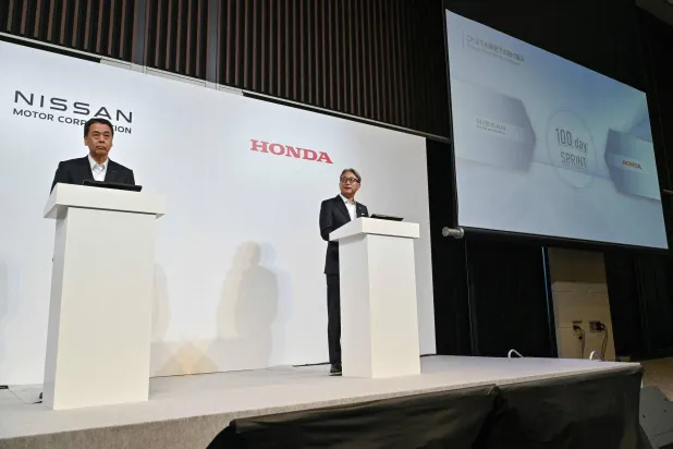 المسؤولان التنفيذيان في كل من «نيسان» و«هوندا» يعلنان خلال مؤتمر صحافي بالعاصمة اليابانية طوكيو خاص باتفاقية للتعاون (أ.ف.ب)