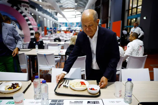 المستشار الألماني أولاف شولتز تناول الطعام مع فريق بلاده في القرية الأولمبية بباريس (أ.ف.ب)