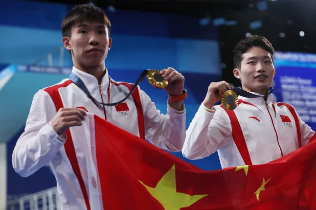 الثنائي الصيني يحتفل بذهبية الغطس المتزامن (رويترز)