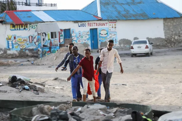 Mogadişu'da bir plajda meydana gelen patlamada hayatını kaybeden kadının naaşını taşıyan insanlar (Reuters)
