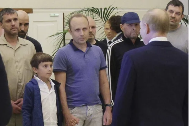 الرئيس الروسي فلاديمير بوتين وبابلو غونزاليس (وسط) ومجموعة من السجناء المفرَج عنهم خلال وصولهم إلى مطار فنوكوفو الحكومي خارج موسكو (أ.ب)