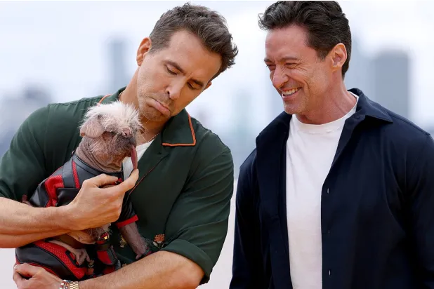 الممثّل رايان رينولدز يحمل الكلبة بيغي (رويترز)