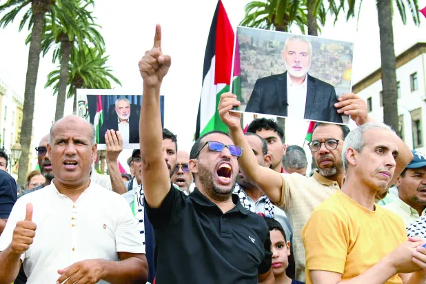 
متظاهرون يرفعون صور إسماعيل هنية خلال مظاهرة في الرباط للتنديد باغتياله (أ.ف.ب)