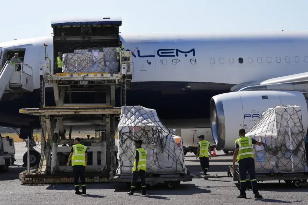 Workers at Beirut airport unload emergency medical aid provided by the World Health Organization (WHO). (AP)