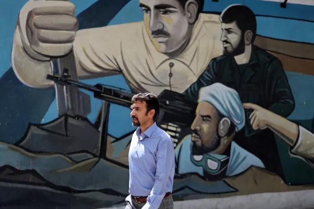 مواطن إيراني يسير في ميدان فلسطين بطهران (إ.ب.أ)