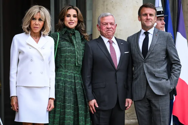 الرئيس الفرنسي إيمانويل ماكرون وعقيلته في استقبال العاهل الأردني الملك عبد الله الثاني وعقيلته على مدخل قصر الإليزيه (أرشيفية - د.ب.أ)