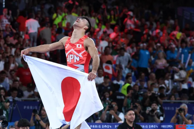 الياباني كينيشيرو فوميتا يحتفل بذهبية المصارعة وزن 60 كيلوغراماً (رويترز)