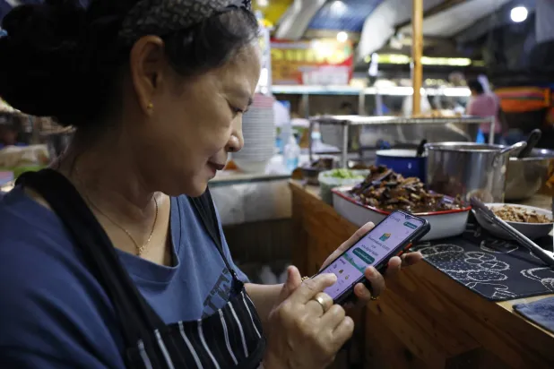 امرأة تستخدم هاتفها الجوال في تايلاند (إ.ب.أ)