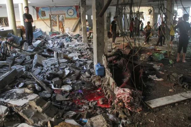 İsrail'in dün Gazze'de yerinden edilen kişilerin sığındığı bir okula düzenlediği saldırının yol açtığı yıkımın ortasındaki kan birikintisi (Reuters)