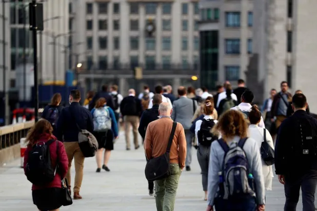 أشخاص يسيرون في الحي المالي بلندن (رويترز)