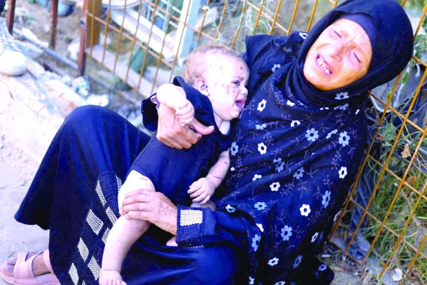 
طفلة فلسطينية فقدت جميع أفراد عائلتها في ضربة إسرائيلية تحتضنها إحدى قريباتها في مستشفى الناصر بخان يونس أمس (رويترز)