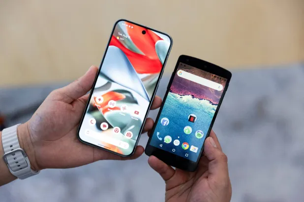 صانع المحتوى أنطونيو كاهون من المكسيك يحمل هاتف «Pixel 9 Pro XL» وهاتف «Nexus 5» الذكي من عام 2013 في حدث Made by Google في ماونتن فيو كاليفورنيا (رويترز)