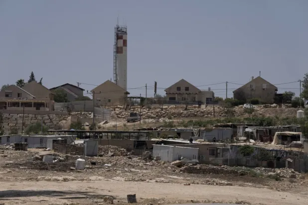 Arka planda 10 Temmuz 2024 tarihinde İsrail'in Carmel yerleşiminin bir kısmı (AP)