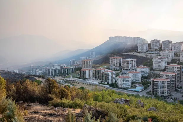 منظر عام لمنطقتي بايراكلي وكارشياكا بعد الحريق مع استمرار جهود الإطفاء والتبريد في اليوم الثاني من حريق إزمير الكبير (د.ب.أ)