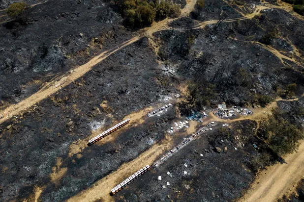 صورة جوية تُظهر خلايا نحل محترقة بعد حريق الغابات في قرية سنجقلي (أ.ف.ب)