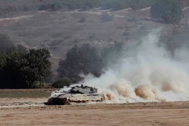 دبابة تناور على الجانب الإسرائيلي من الحدود بين إسرائيل وغزة (رويترز) 