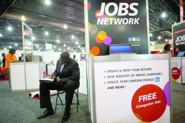 باحث عن عمل يكمل طلب وظيفة بمعرض الوظائف في فيلادلفيا (رويترز)