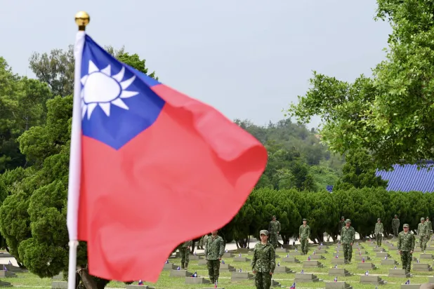 جنود تايوانيون بجانب شواهد قبور الجنود الساقطين خلال الحفل الذي أقيم لإحياء الذكرى السادسة والستين لمعركة المدفعية بين تايوان والصين في كينمن بتايوان في 23 أغسطس 2024 (إ.ب.أ)