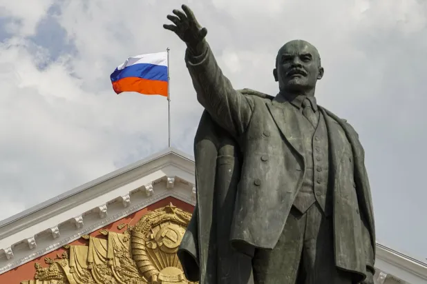تمثال لفلاديمير لينين أمام عَلم روسي وسط مدينة كورسك (أرشيفية - إ.ب.أ)