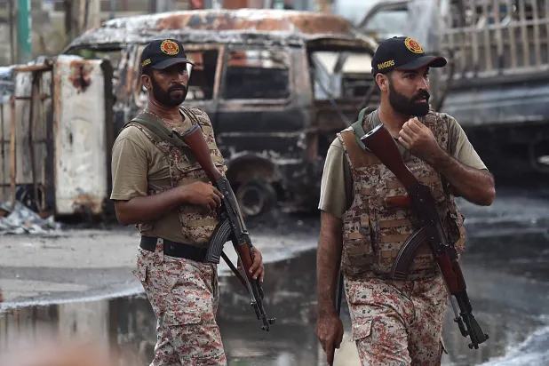 مسؤولون أمنيون باكستانيون يقومون بدورية في موقع الاشتباكات بين مجموعتين مسلحتين في كراتشي، باكستان، 25 أغسطس 2024 (إ.ب.أ)