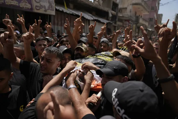 فلسطينيون في الضفة الغربية يشيعون أمس جثمان شاب قتلته القوات الإسرائيلية (أ.ب)