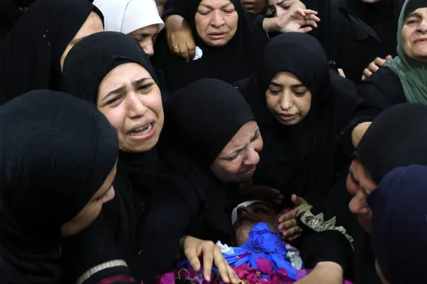 فلسطينيات يشاركن في تشييع أحد قتلى الغارة الإسرائيلي على مخيم نور شمس بطولكرم في الضفة الغربية الثلاثاء (إ.ب.أ)