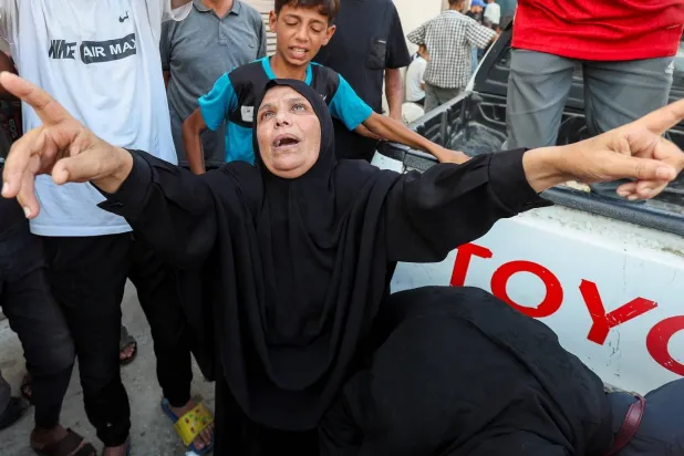 رد فعل فلسطينية خلال جنازة قتلى سقطوا في غارات إسرائيلية على دير البلح وسط قطاع غزة (رويترز)