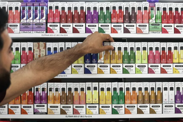 شخص يشتري سجائر إلكترونية في متجر بلندن (إ.ب.أ)