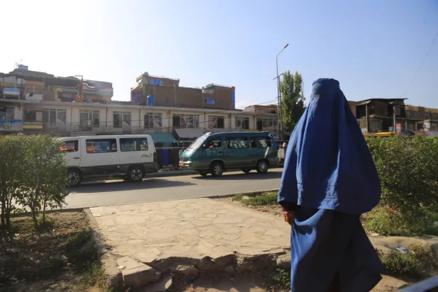 امرأة أفغانية تمشي على إحدى الطرق في كابل (إ.ب.أ)