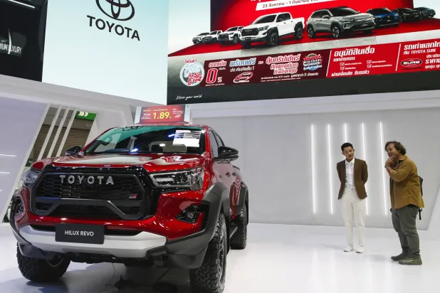 زوار يشاهدون عرضاً لسيارة تويوتا «هيلكس ريفو بيك آب» في معرض «بيغ موتور سيل» بالعاصمة التايلاندية بانكوك (إ.ب.أ)