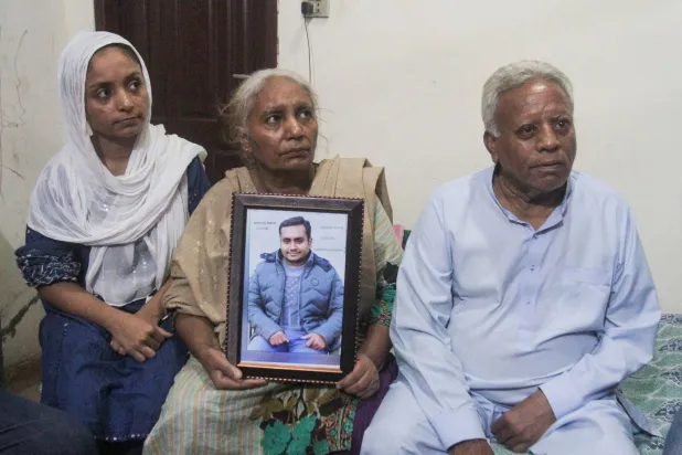 تحسين إقبال تحمل صورة لابنها آصف إقبال الذي قُتل مع آخرين في هجمات مميتة لمسلحين انفصاليين في بلوشستان 27 أغسطس 2024 (رويترز)