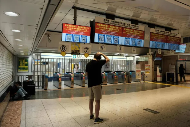 ركاب أمام بوابات التذاكر المغلقة لمنصة «توكايدو شينكانسن» بعد تعليق عمليات القطارات في محطة «جيه آر طوكيو» بسبب الأمطار الغزيرة بطوكيو في 30 أغسطس 2024 (أ.ف.ب)