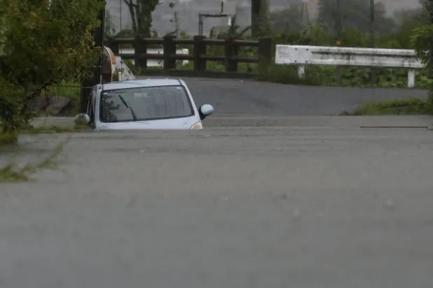 Japonya'nın güneybatısındaki Oita Eyaleti, Yufu'da Shanshan Tayfunu'nun neden olduğu şiddetli yağışlar nedeniyle suya gömülmüş bir araba (Reuters)