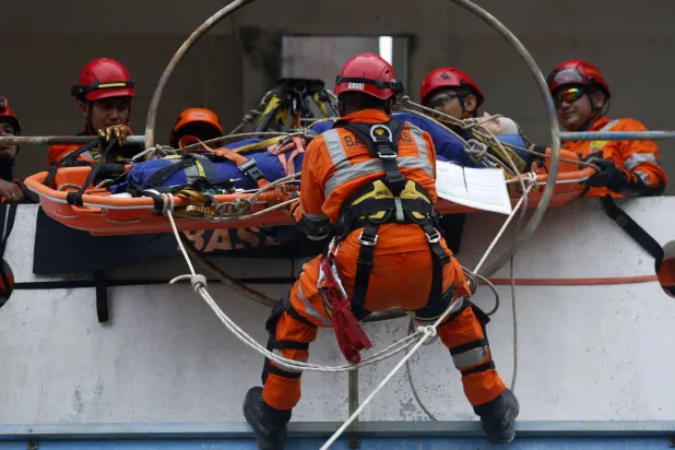 عناصر من البحث والإنقاذ يتدربون على محاكاة لإخلاء ضحايا تسونامي في إندونيسيا (إ.ب.أ)