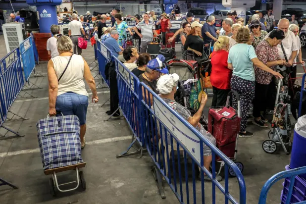 Yardım kuruluşlarından gıda desteği almak isteyen İsrailliler, uzun kuyruklar oluşturuyor (AFP)