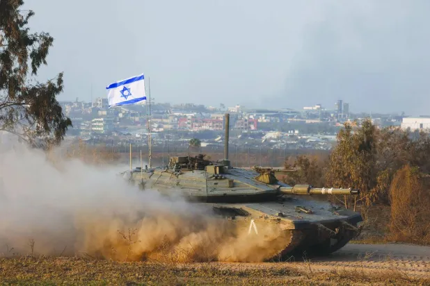 دبابة إسرائيلية تعمل بالقرب من الحدود بين إسرائيل وغزة (رويترز)