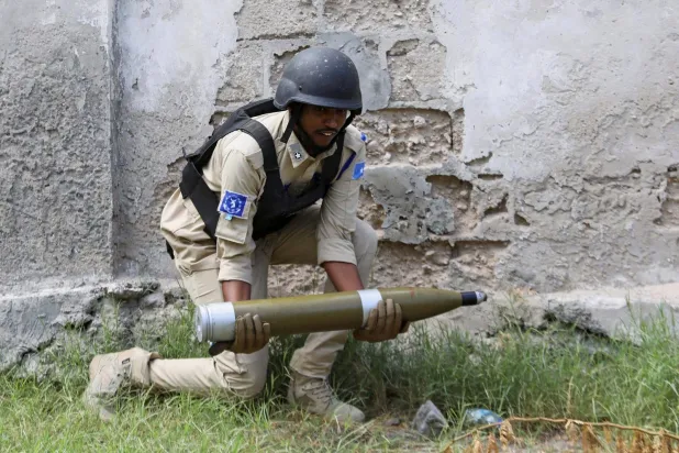 شرطي صومالي يستعد لتفجير محكوم للألغام المستردة على مشارف مقديشو (رويترز)