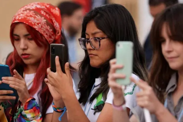 فتيات يستخدمن هواتفهن أثناء مشاركة نشطاء المناخ في احتجاج خلال قمة «كوب 27» بشرم الشيخ بمصر 17 نوفمبر 2022 (أرشيفية - رويترز)
