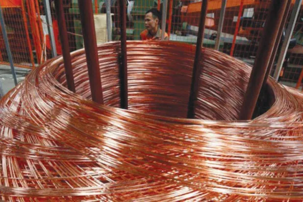 ماكينة تقوم بلفّ أمتار من النحاس في أحد المصانع الصينية (رويترز)