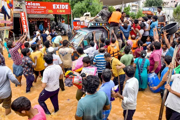 عشرات الهنود يتدافعون للحصول على مساعدات غذائية عقب أمطار موسمية غزيرة في المناطق الجنوبية للبلاد (أ.ف.ب)