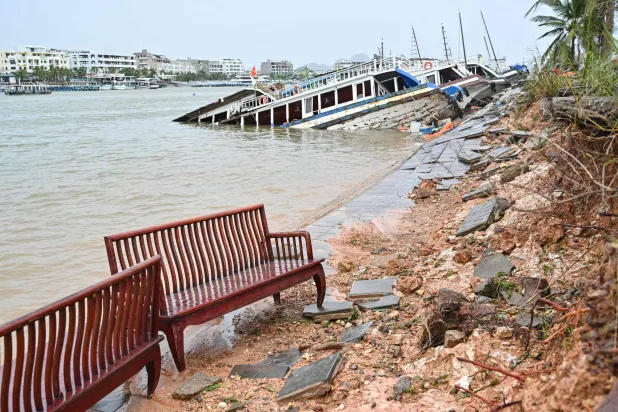 قوارب متضررة وحطام ومقاعد جرفتها الأمواج على الشاطئ بعد أن ضرب الإعصار الفائق «ياغي» خليج هالونغ في مقاطعة كوانغ نينه (أ.ف.ب)