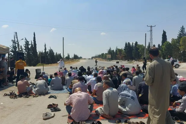 سوريون يؤدون صلاة الجمعة على طريق M4 قرب معبر أبو الزندين شرق حلب (متداولة)