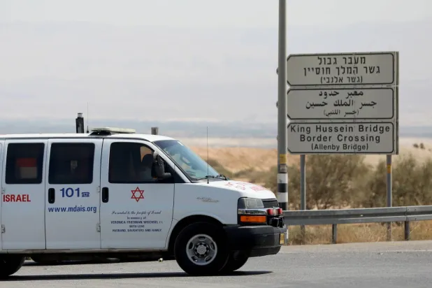 Batı Şeria'nın Eriha şehri yakınlarındaki Kral Hüseyin Köprüsü olarak da bilinen Allenby Köprüsü'nde bir tır şoförünün ateş açtığı yerin yakınlarında seyir halindeki bir ambulans (EPA)