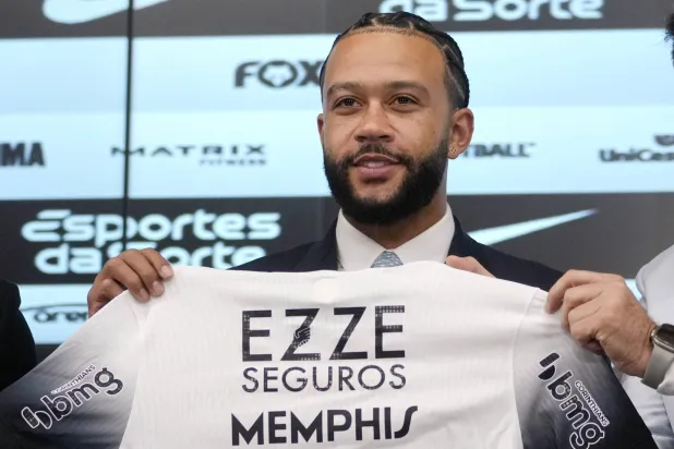 ديباي حاملاً قميص فريقه الجديد كورنثيانز البرازيلي خلال مؤتمر تقديمه للإعلاميين (أ.ب)